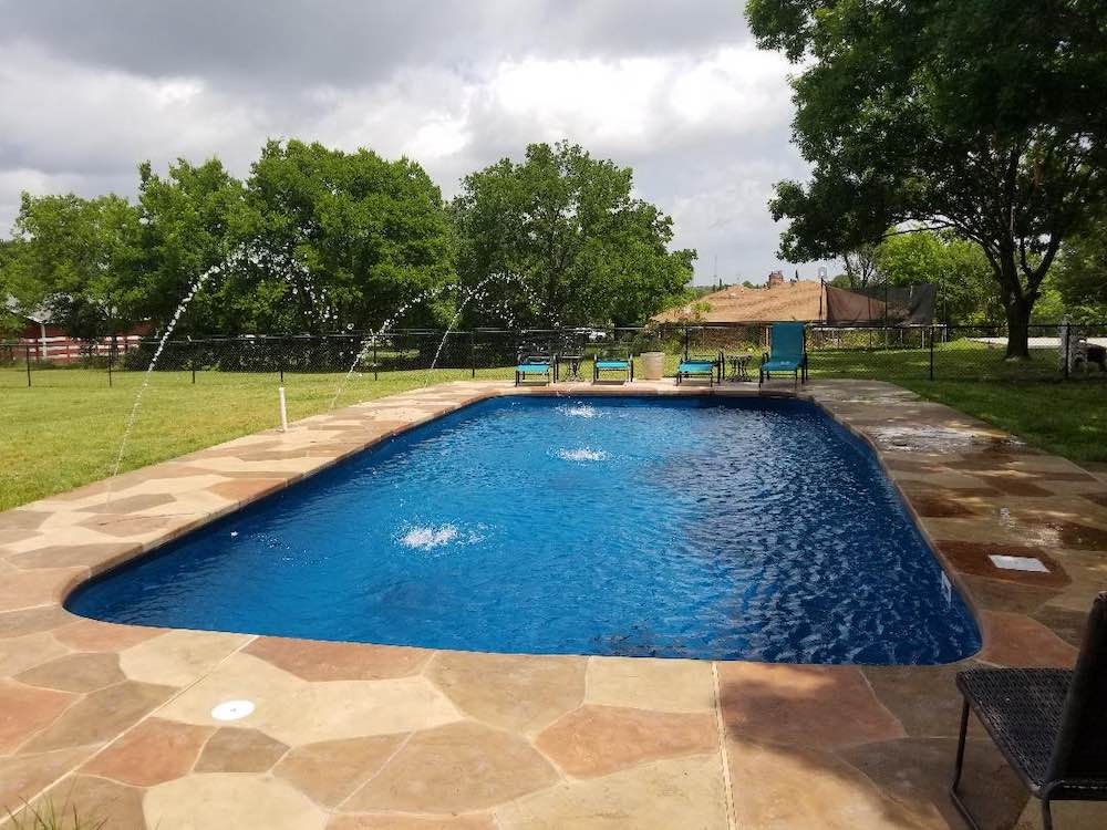 Huntsville TX Fiberglass Pool with decking and lounge chairs